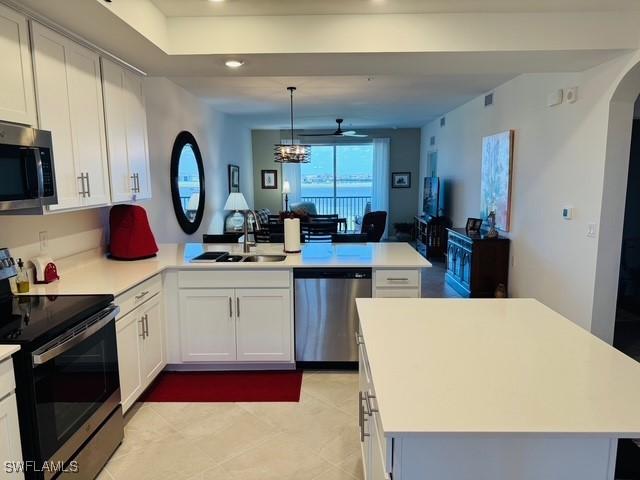 5629 Double Eagle Cir Unit 4224, Ave Maria, FL 34142 - kitchen featuring a peninsula, light tile patterned flooring, light countertops, a sink, and stainless steel appliances