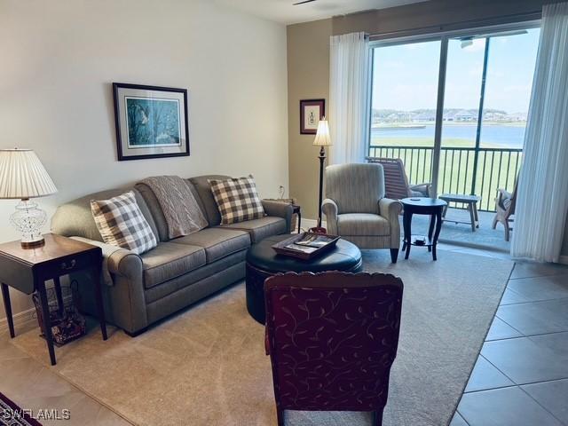 5629 Double Eagle Cir Unit 4224, Ave Maria, FL 34142 - living area featuring tile patterned flooring, baseboards, and a water view