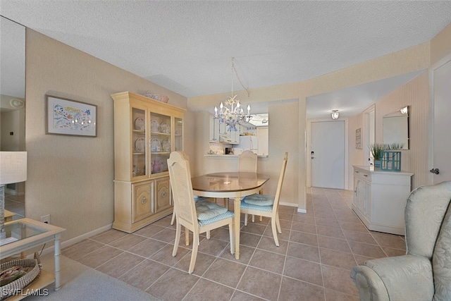 25804 Cockleshell Dr Unit 216, Bonita Springs, FL 34135 - tiled dining area featuring a chandelier, a textured ceiling, and baseboards