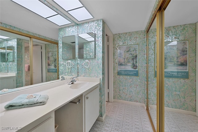 25804 Cockleshell Dr Unit 216, Bonita Springs, FL 34135 - bathroom featuring wallpapered walls, baseboards, and vanity