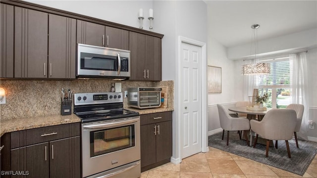 6949 Lone Oak Blvd, Naples, FL 34109 - kitchen with stainless steel appliances, dark brown cabinets, backsplash, a chandelier, and vaulted ceiling