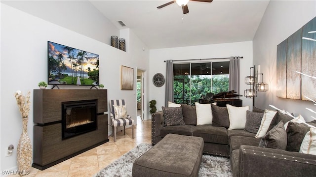 6949 Lone Oak Blvd, Naples, FL 34109 - tiled living room featuring a ceiling fan, a glass covered fireplace, and high vaulted ceiling