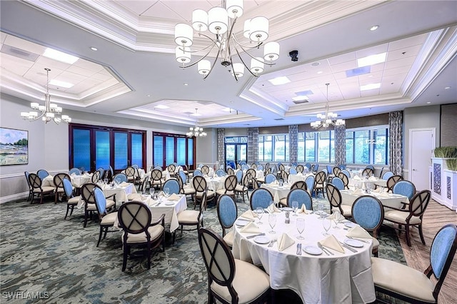 dining space with plenty of natural light, a raised ceiling, ornamental molding, and a notable chandelier