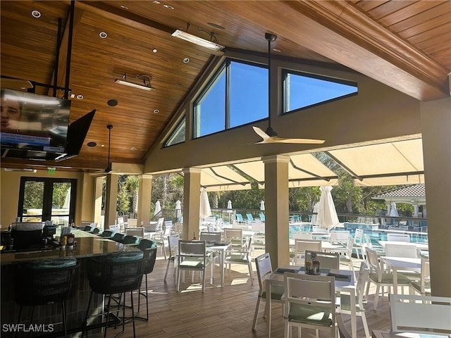 exterior space featuring outdoor dining area, ceiling fan, and a community pool