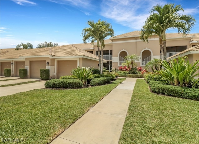 mediterranean / spanish home featuring a garage, a front yard, stucco siding, a tiled roof, and driveway