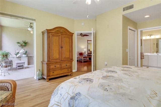 bedroom featuring ceiling fan, light wood-type flooring, ensuite bath, and visible vents