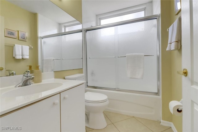 full bath with vanity, tile patterned flooring, bath / shower combo with glass door, and toilet