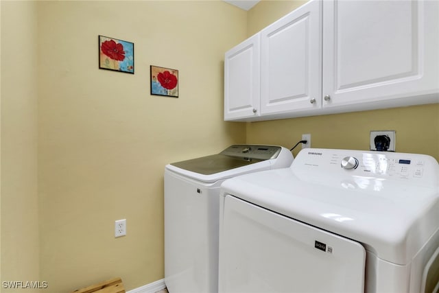 washroom with cabinet space and washer and dryer