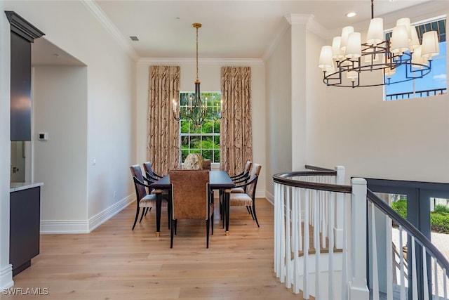 dining area with baseboards, a notable chandelier, ornamental molding, and light wood-style floors