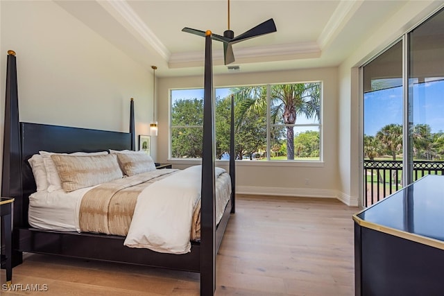 bedroom with crown molding, access to outside, and a tray ceiling
