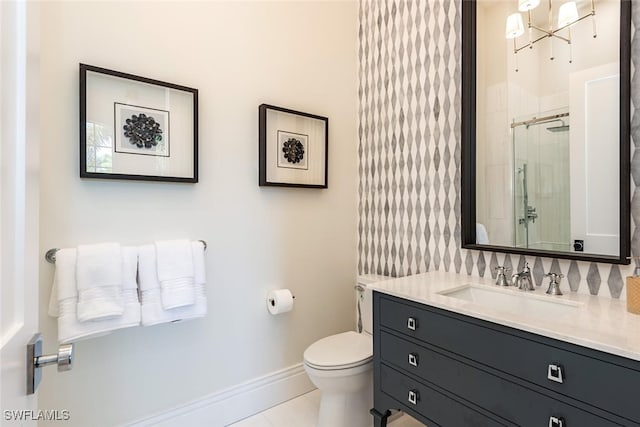 bathroom with vanity, toilet, tile patterned floors, baseboards, and a stall shower