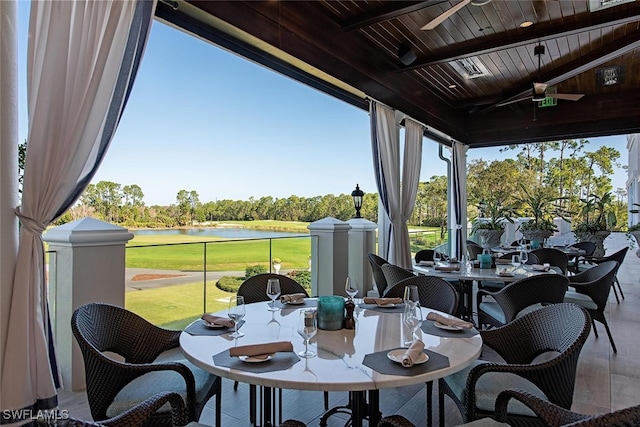 sunroom with a water view, beamed ceiling, and golf course view