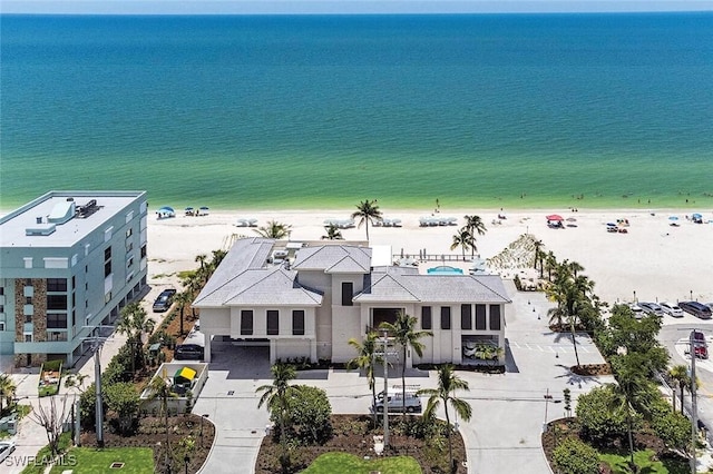 birds eye view of property featuring a water view and a beach view