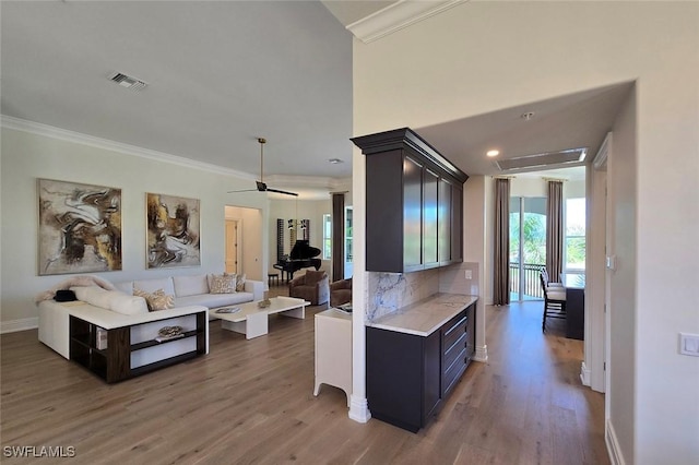 16995 Porta Vecchio Way Unit 202, Naples, FL 34110 - kitchen featuring light countertops, light wood-style floors, ornamental molding, open floor plan, and baseboards