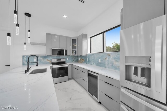 4026 SE 3rd Ave, Cape Coral, FL 33904 - kitchen featuring appliances with stainless steel finishes, modern cabinets, gray cabinetry, light stone counters, and a sink