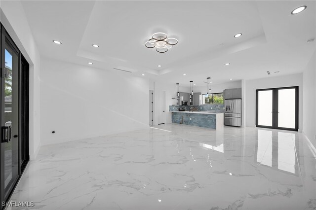 4026 SE 3rd Ave, Cape Coral, FL 33904 - unfurnished living room featuring a raised ceiling, baseboards, recessed lighting, and marble finish floor