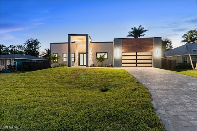 4026 SE 3rd Ave, Cape Coral, FL 33904 - contemporary house with fence, a garage, stucco siding, a front yard, and decorative driveway
