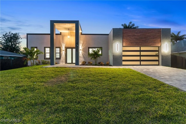 4026 SE 3rd Ave, Cape Coral, FL 33904 - contemporary house with fence, an attached garage, stucco siding, decorative driveway, and a lawn