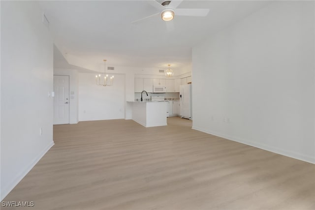 unfurnished living room with a chandelier, a sink, light wood-type flooring, a ceiling fan, and baseboards