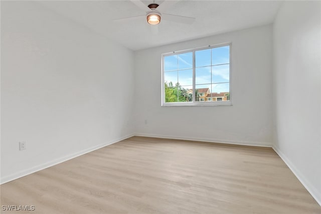 empty room featuring light wood-style floors, ceiling fan, and baseboards