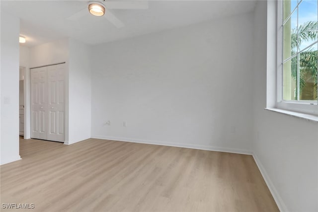 spare room with wood finished floors, ceiling fan, and baseboards