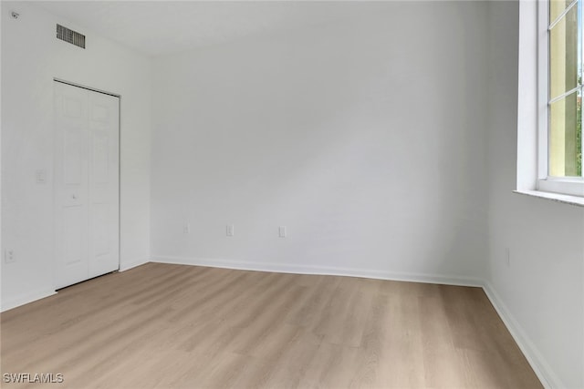 spare room with light wood-style flooring and baseboards