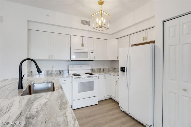 kitchen featuring white appliances, a sink, white cabinetry, a chandelier, and light stone counters
