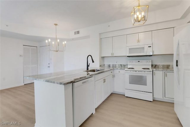 kitchen featuring white appliances, a chandelier, a sink, and light wood-type flooring
