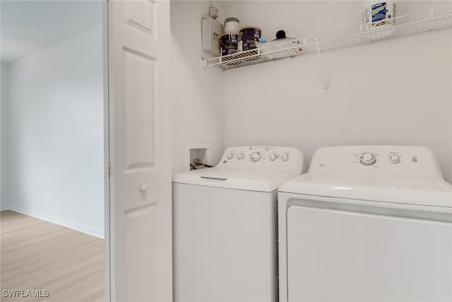 laundry area featuring separate washer and dryer and light wood-type flooring