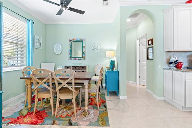 dining area with crown molding, arched walkways, a ceiling fan, and visible vents