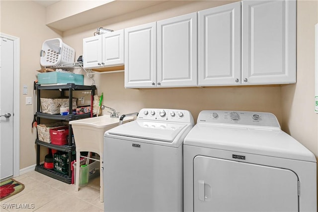 laundry area with cabinet space, washer and clothes dryer, and light tile patterned floors