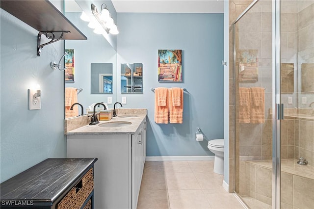 bathroom with double vanity, toilet, a stall shower, a sink, and tile patterned floors