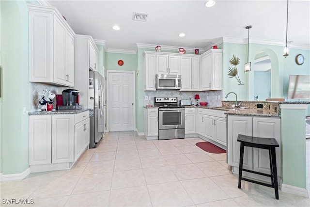 kitchen with a sink, a peninsula, stainless steel appliances, tasteful backsplash, and crown molding