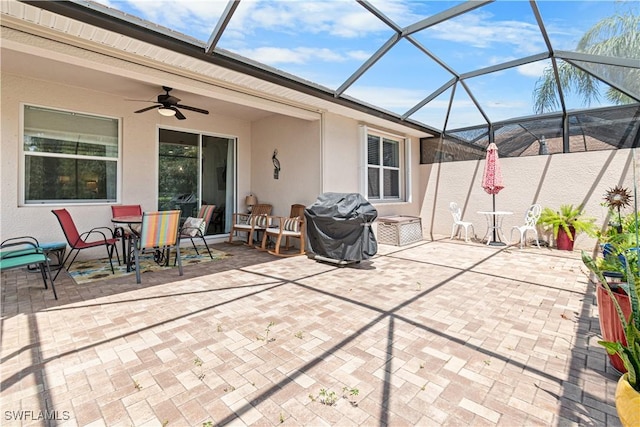 view of patio / terrace with a grill, outdoor dining area, a ceiling fan, and a lanai