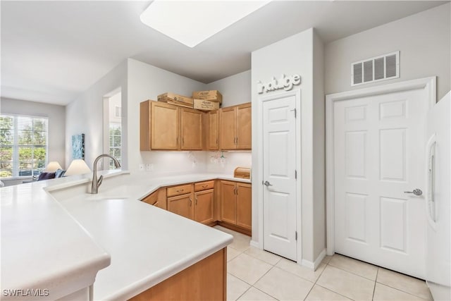 kitchen featuring light countertops, light tile patterned flooring, visible vents, and a sink