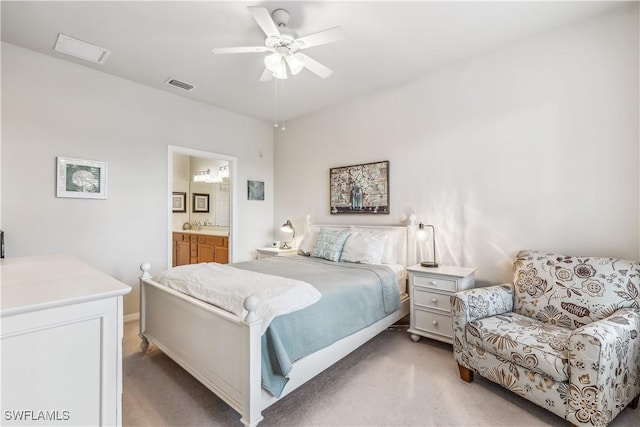 bedroom with ensuite bath, visible vents, and light carpet