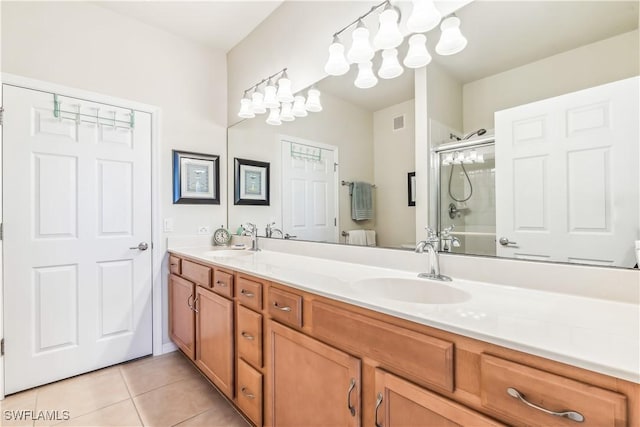 bathroom featuring a sink, tile patterned floors, a shower with shower door, and double vanity