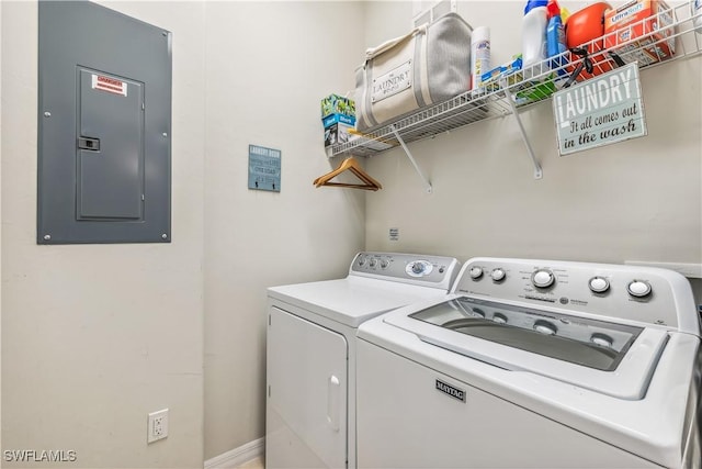 washroom with electric panel, washing machine and dryer, and laundry area