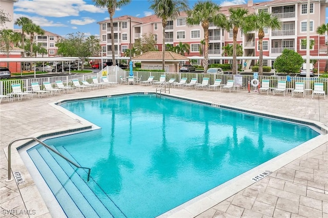 pool with a patio and fence