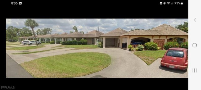 321 Dania St, Lehigh Acres, FL 33936 - view of front of property with concrete driveway, a front yard, and an attached garage