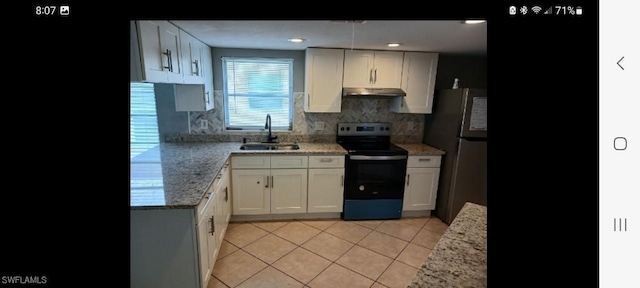 321 Dania St, Lehigh Acres, FL 33936 - kitchen with range with electric stovetop, freestanding refrigerator, a sink, under cabinet range hood, and light tile patterned floors