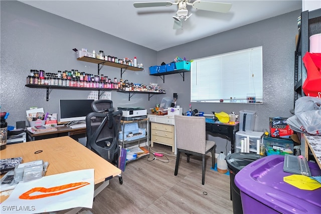 home office with a textured wall, a ceiling fan, and wood finished floors