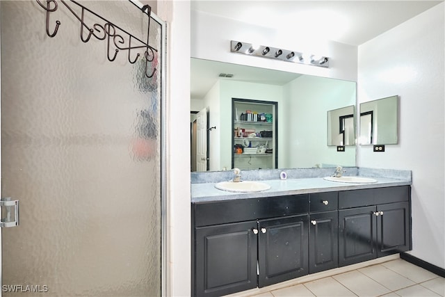 full bath with a stall shower, tile patterned floors, and double vanity