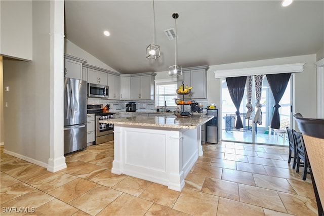 kitchen with stainless steel appliances, gray cabinets, backsplash, lofted ceiling, and a kitchen island