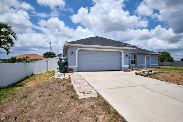ranch-style home with stucco siding, an attached garage, fence, driveway, and a gate
