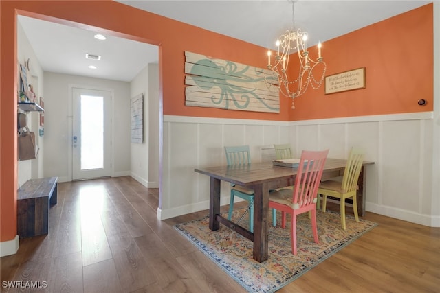 20263 Cypress Shadows Blvd, Estero, FL 33928 - dining room with a decorative wall, wood finished floors, visible vents, an inviting chandelier, and wainscoting