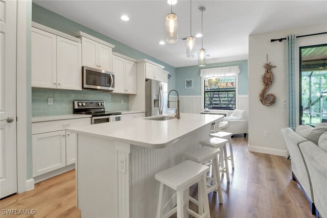 20263 Cypress Shadows Blvd, Estero, FL 33928 - kitchen featuring a breakfast bar, an island with sink, open floor plan, light countertops, and appliances with stainless steel finishes