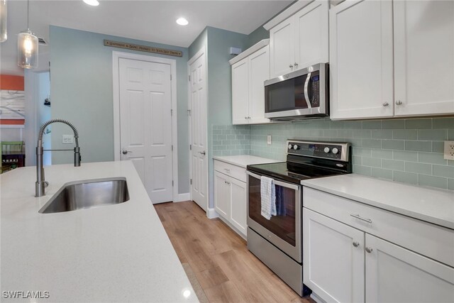 20263 Cypress Shadows Blvd, Estero, FL 33928 - kitchen featuring stainless steel appliances, recessed lighting, a sink, light wood-style floors, and light countertops