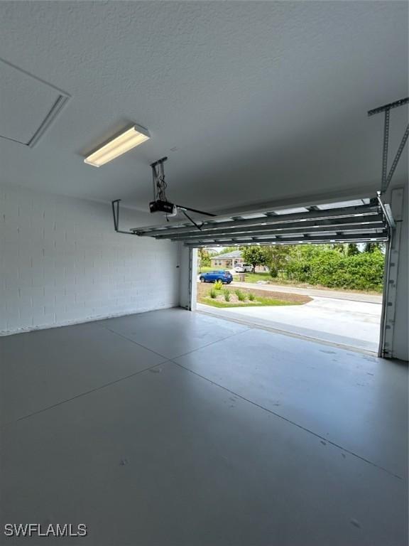 5525 Berryman St, Lehigh Acres, FL 33971 - garage with concrete block wall and a garage door opener