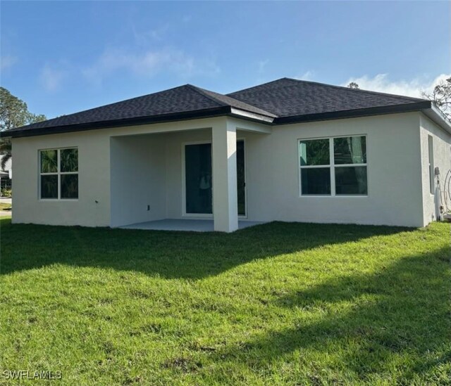 5525 Berryman St, Lehigh Acres, FL 33971 - rear view of house featuring a lawn, a patio, a shingled roof, and stucco siding
